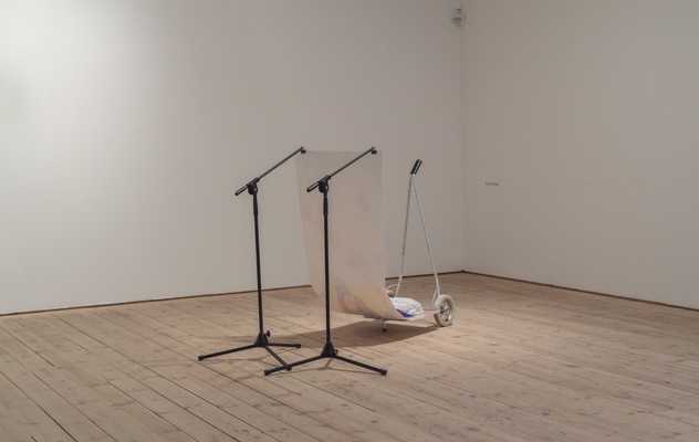 Two microphone tripods holding up a print of a lidl plastic bag